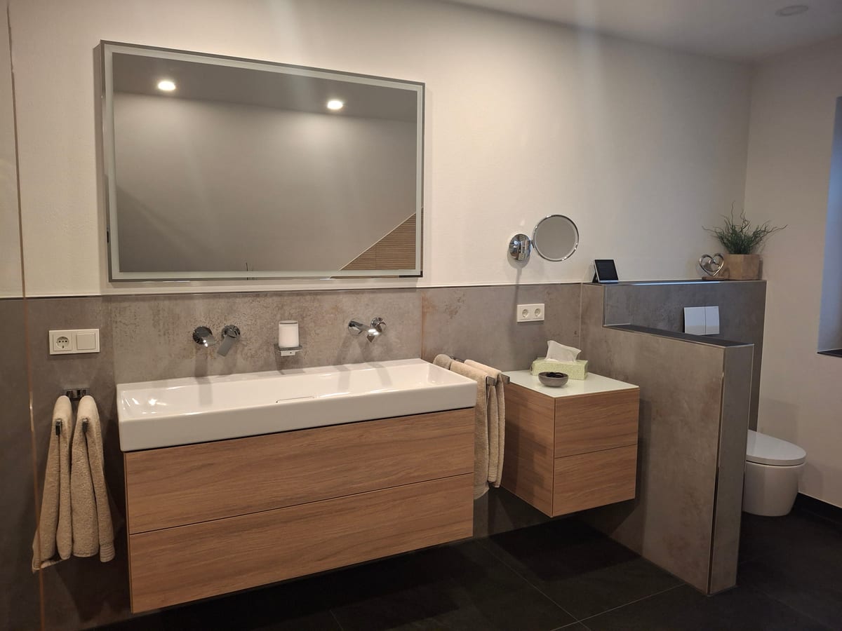 Modernes Bad mit Doppelwaschtisch in Holzoptik, großem Spiegel und bodengleicher Dusche